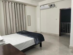 a white room with a bed and a window at Windfall Homestay in Dimapur