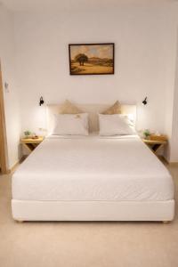 a large white bed in a room with two tables at Exclusive Olive & Herb Villa, Mountain to Sea Views, Rhodes in Afantou
