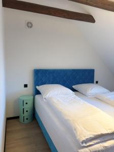 a bed with a blue headboard in a bedroom at Hafen33 in Leer
