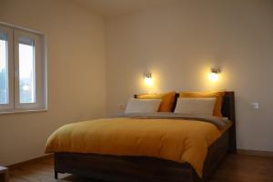 a bedroom with a bed with yellow sheets and a window at Velebit Escape Apartments in Starigrad