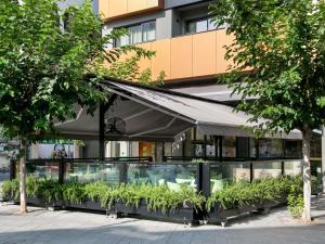 a building with a bunch of plants in front of it at Mercure Larnaca Finikoudes Beach in Larnaca