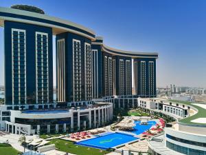 a large building with a pool in front of it at Rixos Premium Alamein in El Alamein