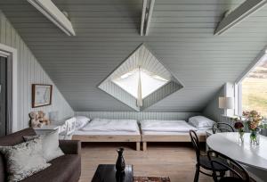 a attic room with a bed and a window at Silfurberg in Þorgrímsstaðir