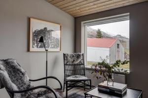 a living room with a chair and a table and a window at Silfurberg in Þorgrímsstaðir