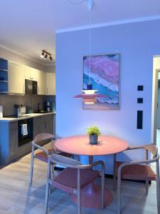 a table and chairs in a kitchen with a blue wall at Hafen33 in Leer