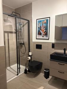 a bathroom with a black toilet and a shower at Hafen33 in Leer +27 photos