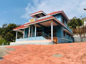 a blue house with a red roof at Kalon Elpis Villa in Ooty