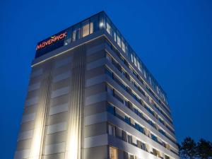 a building with a sign on the top of it at Mövenpick Hotel Brussels Airport in Zaventem