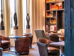 a room with chairs and tables and a book shelf at L'Isle de Leos Hotel & Spa - MGallery Collection in L'Isle-sur-la-Sorgue