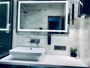 a bathroom with a white sink and a mirror at Lumbini in Varanasi