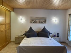 a bedroom with a large bed with two crosses on the wall at Villa Rose in Seignosse +48 photos
