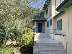 a staircase leading to a house with a blue door at Villa Rose in Seignosse