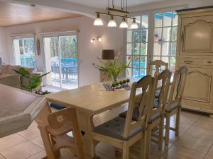 a kitchen and dining room with a wooden table and chairs at Villa Rose in Seignosse