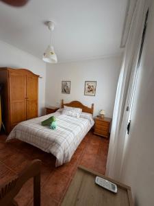 a bedroom with a bed with a green stuffed animal on it at Casa Fuenteblanca in Liétor