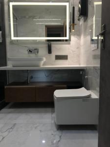 a bathroom with a sink and a toilet and a mirror at Lumbini in Varanasi