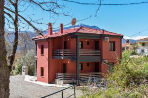 a red house on the side of a hill at Elia Deluxe Accommodation in Kalabaka