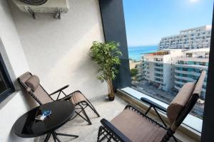 a balcony with a table and chairs and a view of the ocean at Building Stefan Resort 2 Mamaia Nord - Studio 804 in Năvodari