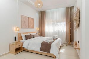a white bedroom with a large bed and a window at Taghazout Bay Chic Residence Sea View in Tamraght Ouzdar +29 photos