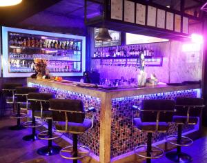 a bar with bar stools in a room at Puttaya Glow in Pattaya