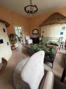 a bedroom with a bed and a couch and a chandelier at Riverside Landhaus-Villa und Lodge XXL Garten bis 24 Personen in Mittelhof