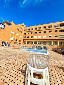a white chair sitting in front of a building at Taghazout Bay Chic Residence Sea View in Tamraght Ouzdar