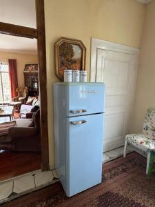 a white refrigerator in a room with a living room at Riverside Landhaus-Villa und Lodge XXL Garten bis 24 Personen in Mittelhof