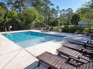 a swimming pool with two benches and a poolvisorvisorvisor at New Home 3br/25br w/ kayak access sleeps 9 in Orange Beach