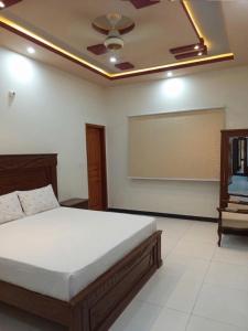a bedroom with a bed and a chalkboard on the wall at Nursery Suites in Karachi