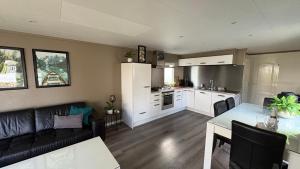 a kitchen and living room with a couch and a table at Luxe Chalet 146 in Putten
