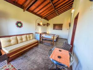 a living room with a couch and a table at Pousada Alem das Formas in Carrancas