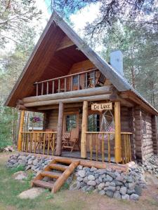 a log cabin with a porch and a deck at Mõnus palkmaja Muhu mändide all in Nõmmküla