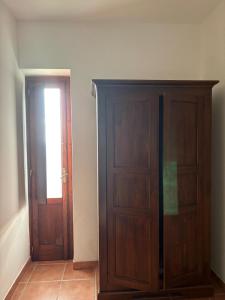 a room with a wooden cabinet and a door at La Dimora del Molo in Fuscaldo