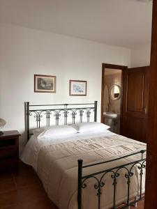 a bedroom with a large bed with white sheets at La Dimora del Molo in Fuscaldo