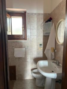 a bathroom with a white toilet and a sink at La Dimora del Molo in Fuscaldo