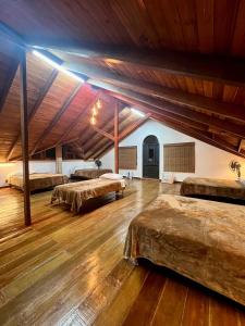 a large room with three beds and wooden ceilings at Finca Premium en el Eje Cafetero in Ulloa +53 photos