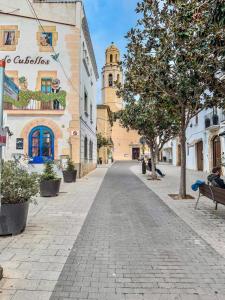 an empty street in a town with a clock tower at Casa Centenaria 1769 in Cubelles