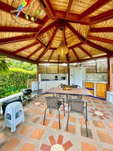 a patio with a table and chairs under a wooden ceiling at Finca Premium en el Eje Cafetero in Ulloa