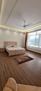 a bedroom with a bed and a large window at Abbott royale farm in Abbottabad