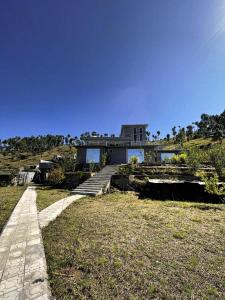 a house on top of a hill with a pathway at Abbott royale farm in Abbottabad