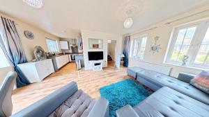 a living room with a couch and a tv at Sunset Cottage - Part of the The Bay Filey Holiday Village with pool, gym and direct beach access, pub, restaurant, tennis and meadows walks in Filey