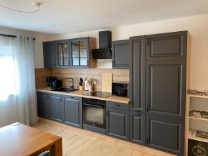a kitchen with gray cabinets and a wooden table at Ferienwohnung Rickelhoff in Olpe
