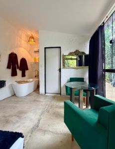 a bathroom with a couch and a table and a tub at Studio Bali - Village Capixaba in Gravatá