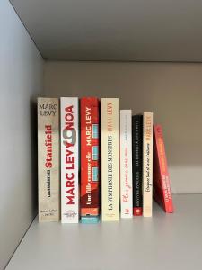 a row of books sitting on a shelf at L'Escapade Bourguignonne, à 10 minutes de Cluny, petit déjeuner inclus! in Clermain