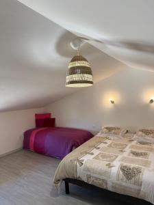 a bedroom with two beds and a pendant light at L'Escapade Bourguignonne, à 10 minutes de Cluny, petit déjeuner inclus! in Clermain