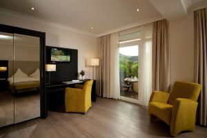 ein Hotelzimmer mit Bett, Schreibtisch und Stühlen in der Unterkunft Hotel Restaurant Pollmanns in Ernst
