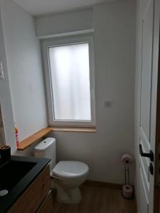 a bathroom with a white toilet and a window at nid doré in Calais