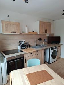 a kitchen with wooden cabinets and a sink and a dishwasher at nid doré in Calais