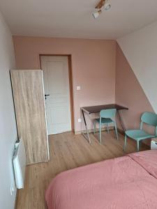 a bedroom with a bed and a table and two chairs at nid doré in Calais