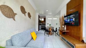 a living room with a blue couch and a television at (103) Coastal seaside - Pebble in Pimenta