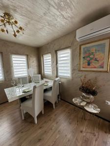 a dining room with a table and chairs and windows at Christian Dior Lazarevac in Lazarevac
